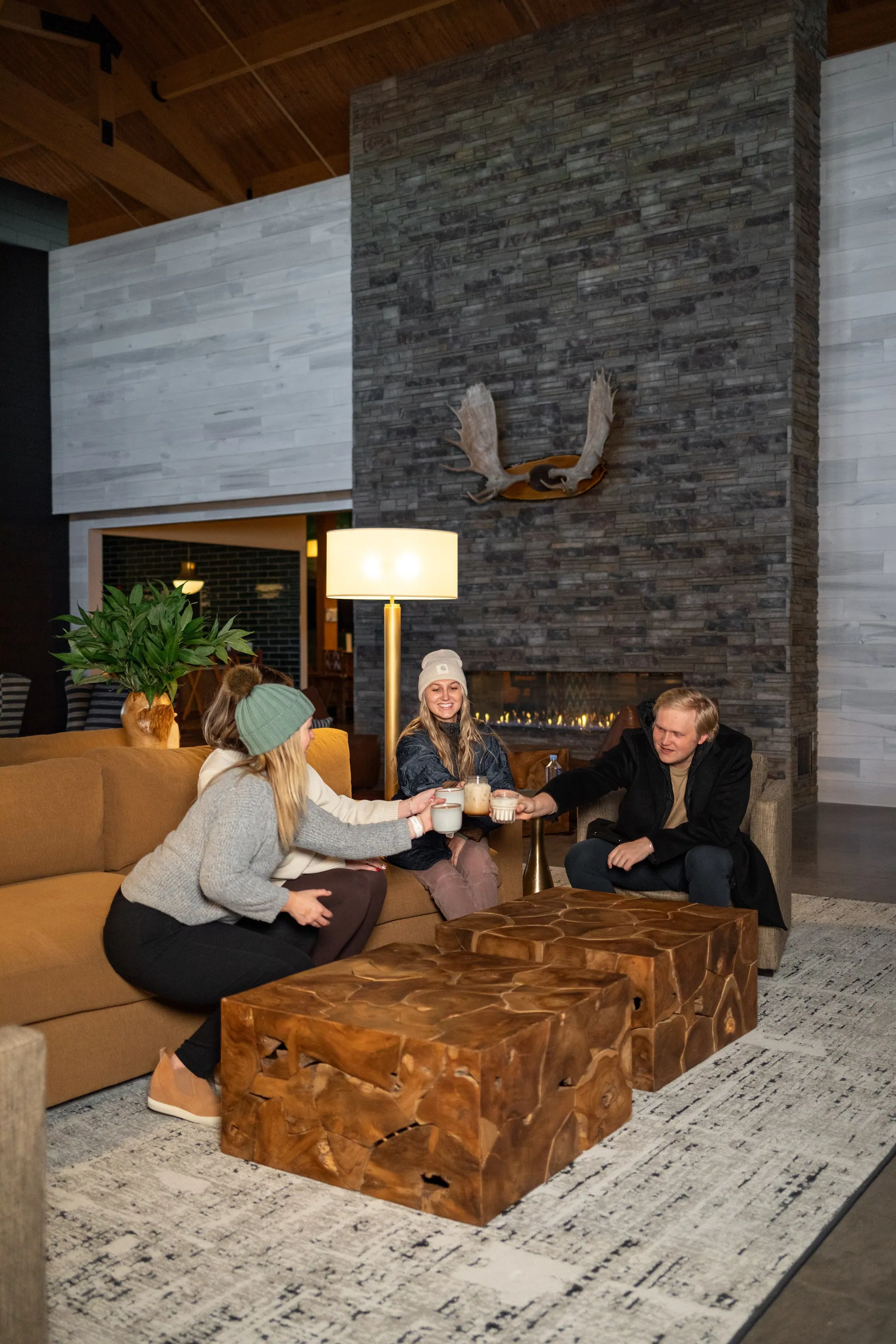 Friends by the stone fireplace in the bantr grand hotel lobby